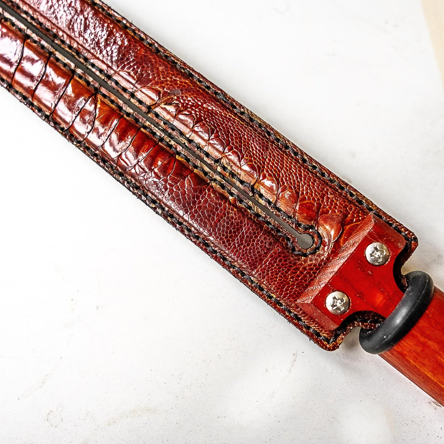Tawse/Ostrich/Dark Amber. 51cm/20", double-tongued paddle made of layered leather with carbon inlay
