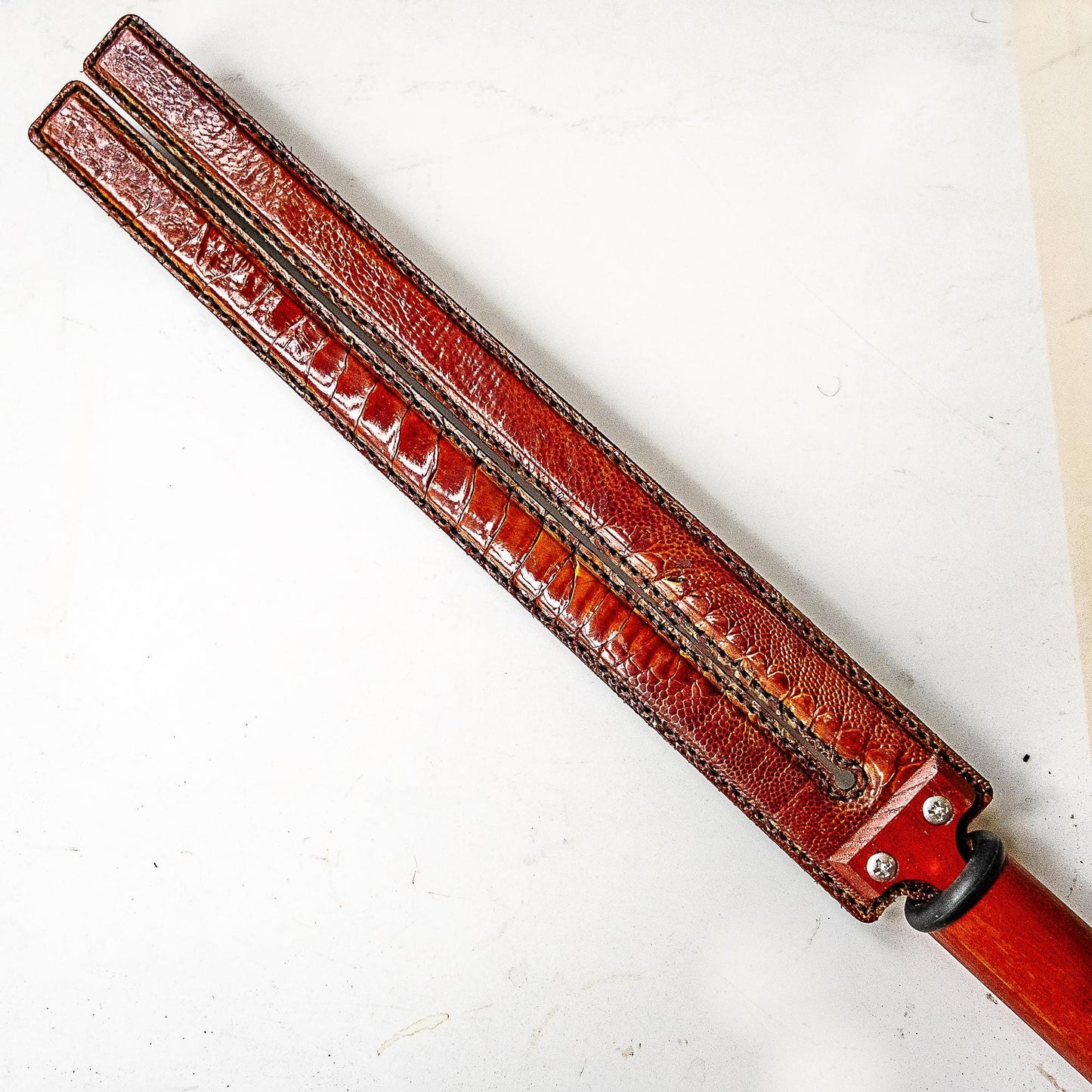 Tawse/Ostrich/Dark Amber. 51cm/20", double-tongued paddle made of layered leather with carbon inlay
